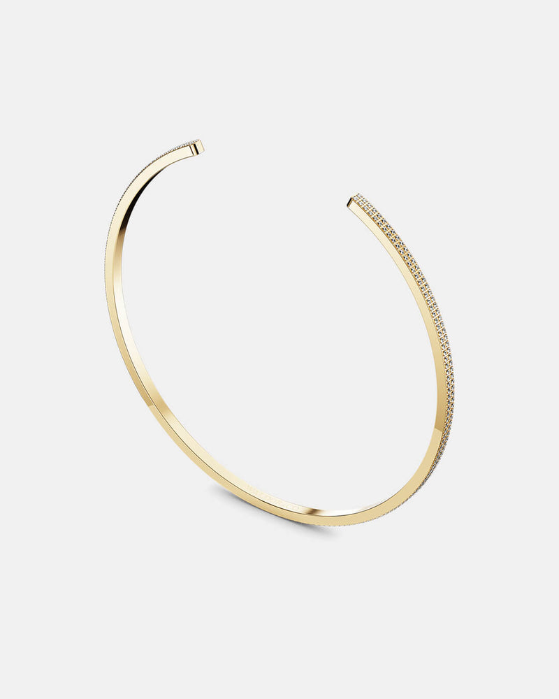 A polished stainless steel bangle in 14k gold from Waldor & Co. One size. The model is Pave Bangle Polished. 